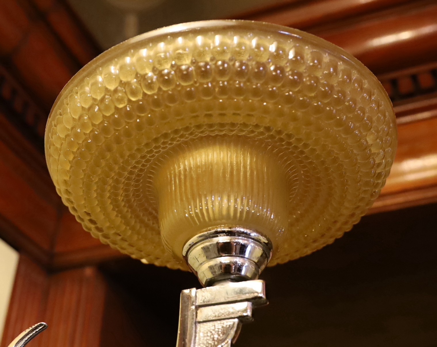 A French Art Deco nickel plated wall light with moulded glass shade and antelope stem, height 30cm. depth 35cm